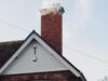 A brick chimney emitting smoke