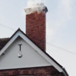 A brick chimney emitting smoke